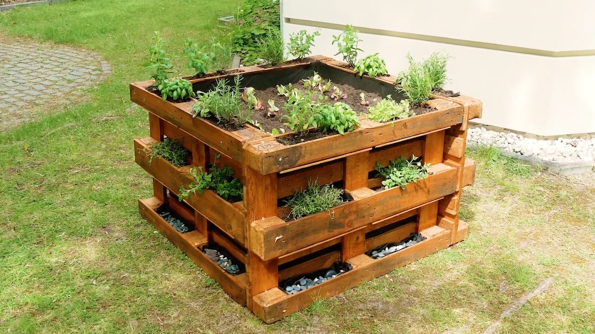 Das fertige Hochbeet aus Paletten mit verschiedenen Pflanzen bepflanzt.