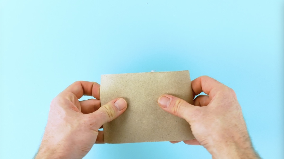 Jemand hält eine aufgeschnittene Klopapierrolle in der Hand