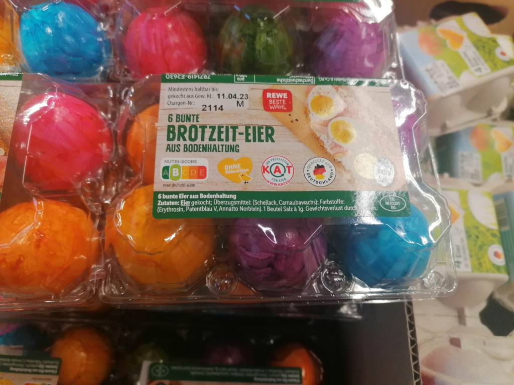 Eine Packung mit gefärbten Ostereiern im Supermarkt. Achte beim Kauf dieses Produkts zumindest auf das KAT-Logo.