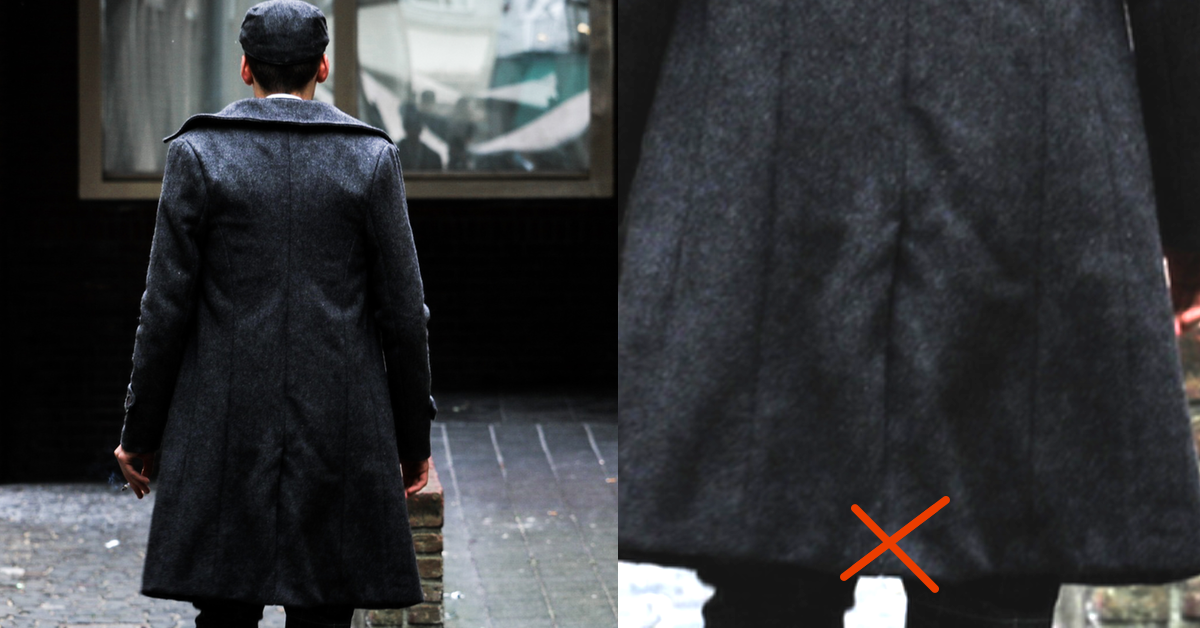 Mann trägt langen Mantel mit zugenähtem Mantelschlitz. Die Heftnaht an dem Schlitz sollte man besser auftrennen.