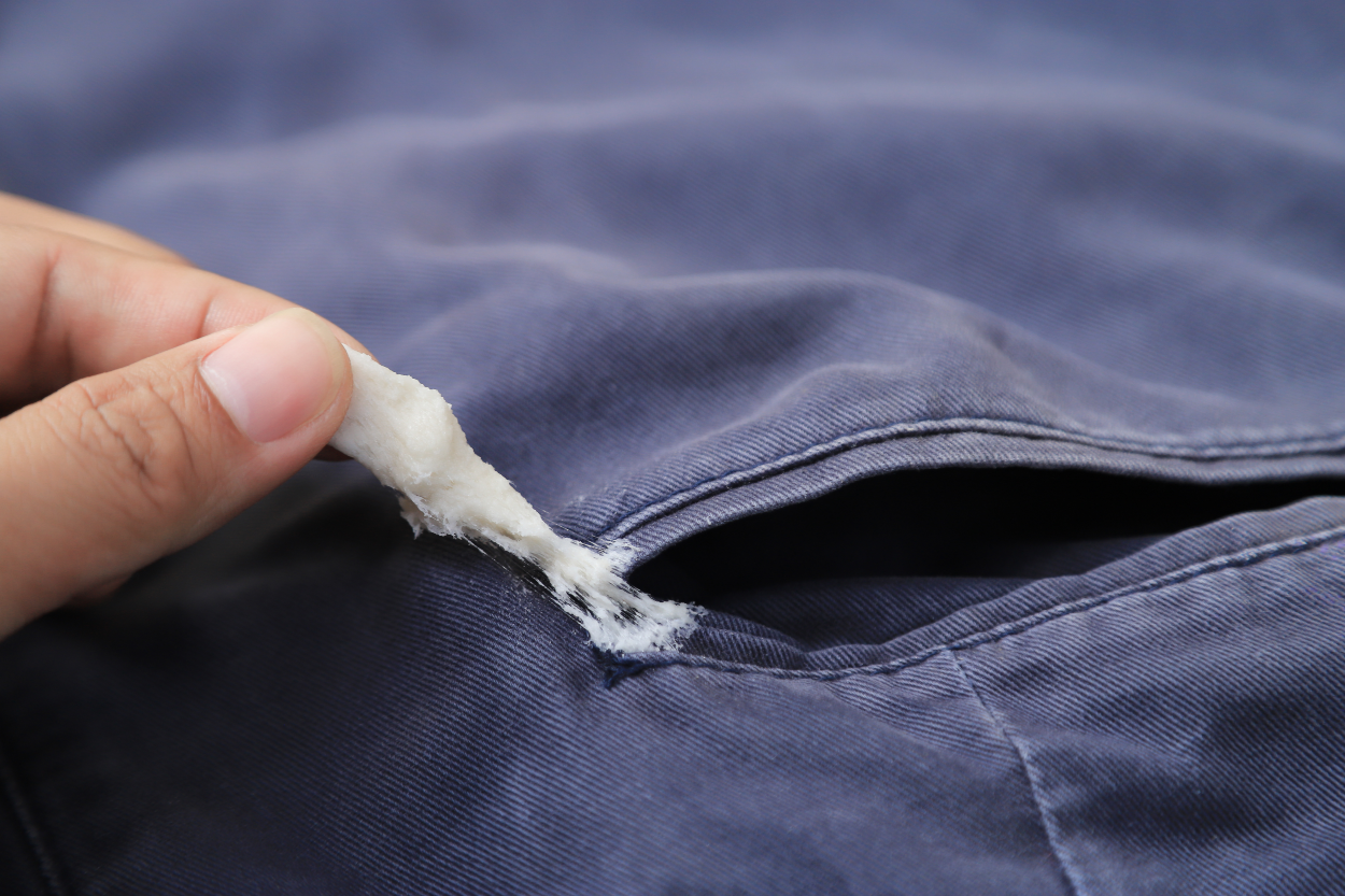 putztrick kaugummi entfernen Jemand versucht, einen festgeklebten Kaugummi von einer Hose zu entfernen. Mithilfe eines simplen Putztricks gelingt es leichter.
