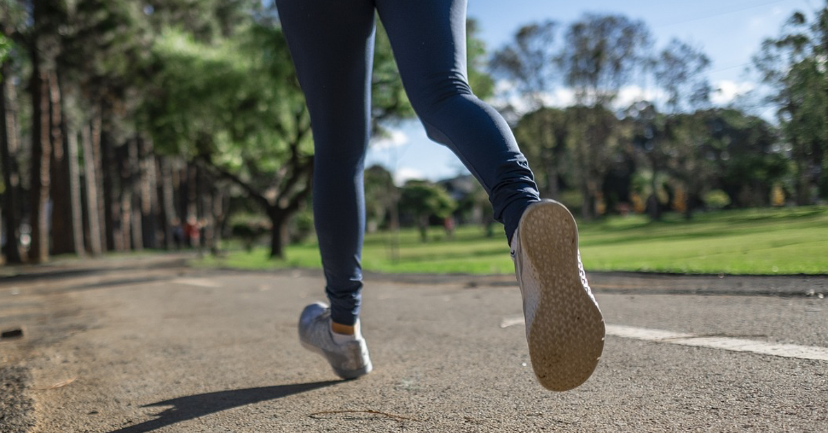 GrundÃ¼bung: Eine Frau joggt auf einer asphaltierten StraÃŸe.