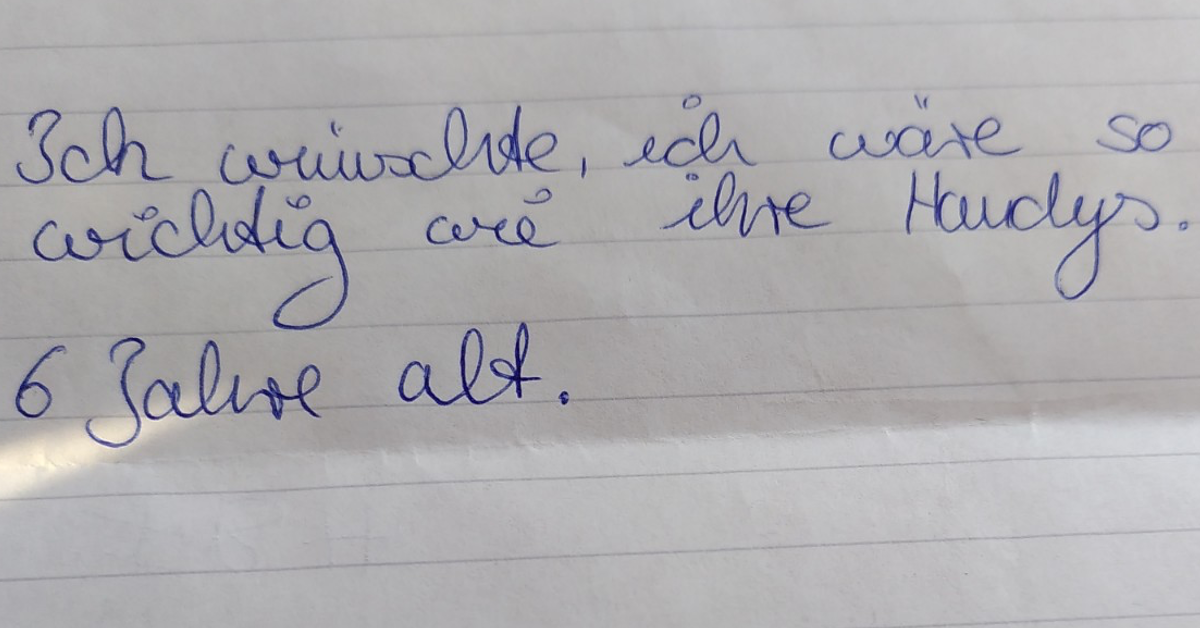 Ein liniertes Blatt Papier, auf dem mit blauem Kugelschreiber geschrieben steht: „Ich wünschte, ich wäre so wichtig wie ihre Handys.“ 6 Jahre alt