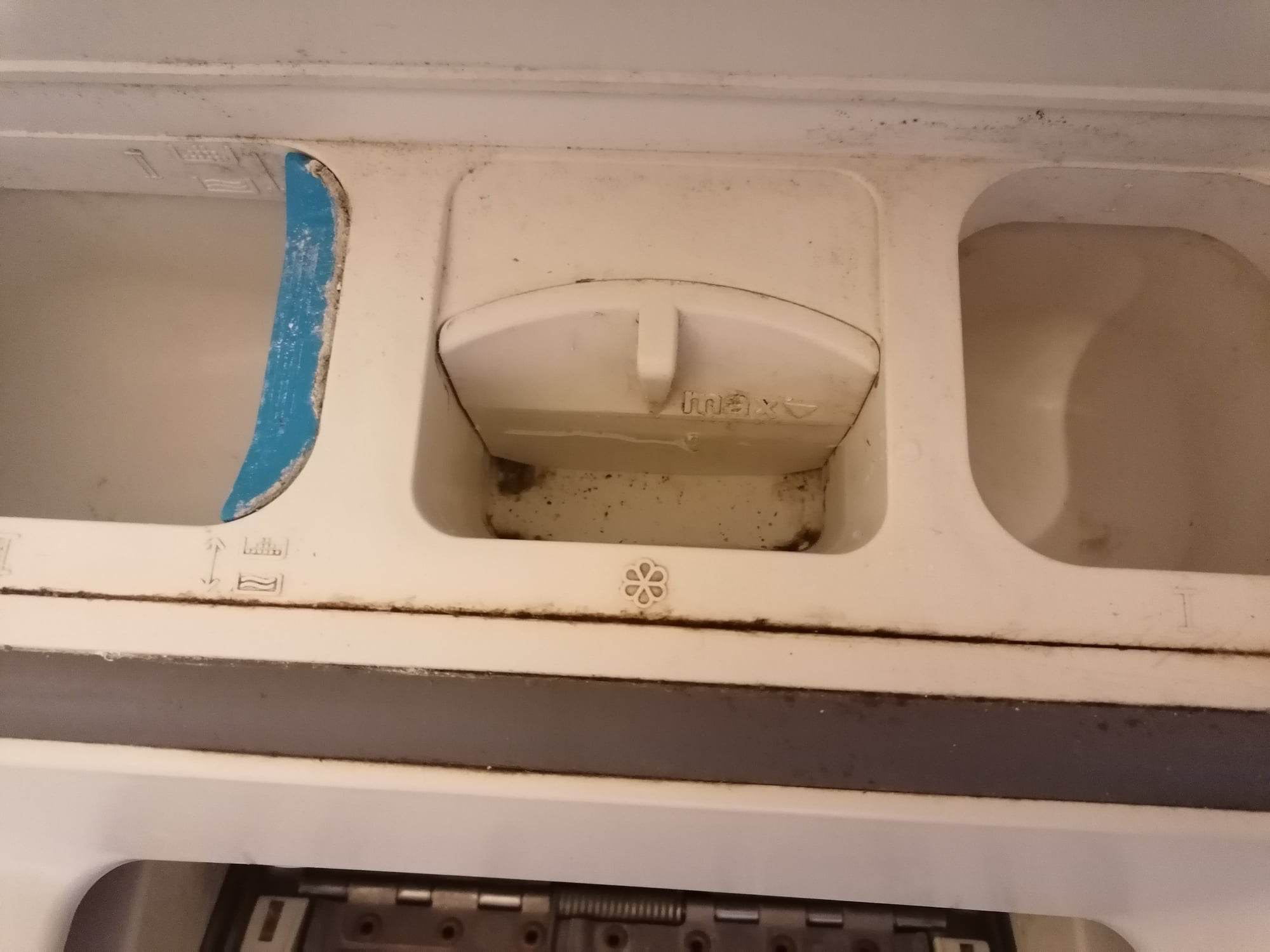 Wasser im Weichspülfach einer dreckigen Waschmaschine.