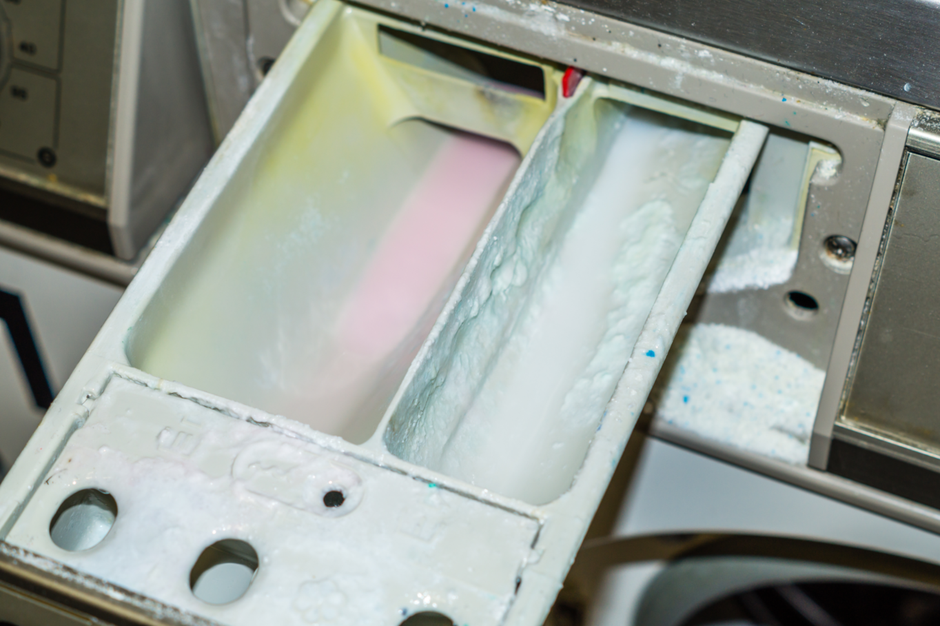 Wasser und Waschmittelreste im WeichspÃ¼lerfach einer Waschmaschine.