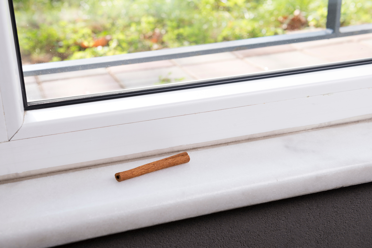 Eine Zimtstange auf dem Fensterbrett. Zimt ist ein effektives Hausmittel gegen Ameisen.