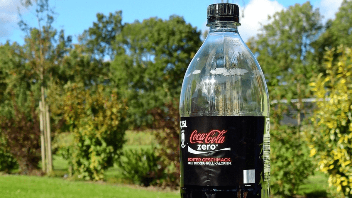 Eine Cola-zero-Flasche steht auf einem Tisch im Garten.