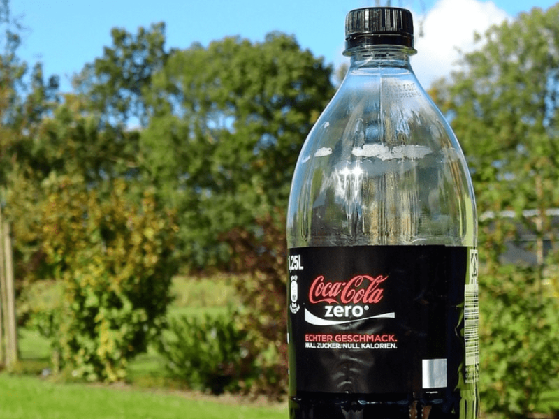 Eine Cola-zero-Flasche steht auf einem Tisch im Garten.