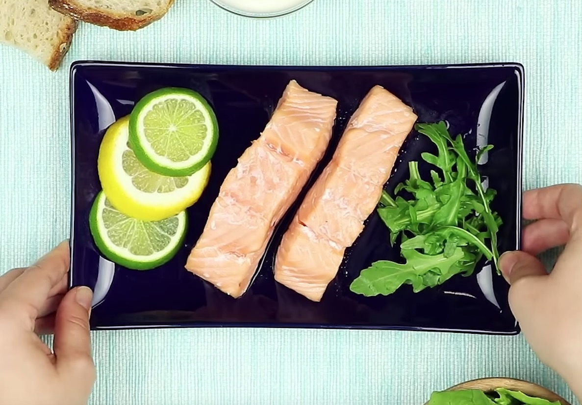 Ein Teller, auf dem Zitronen, Fisch und Salat serviert werden.