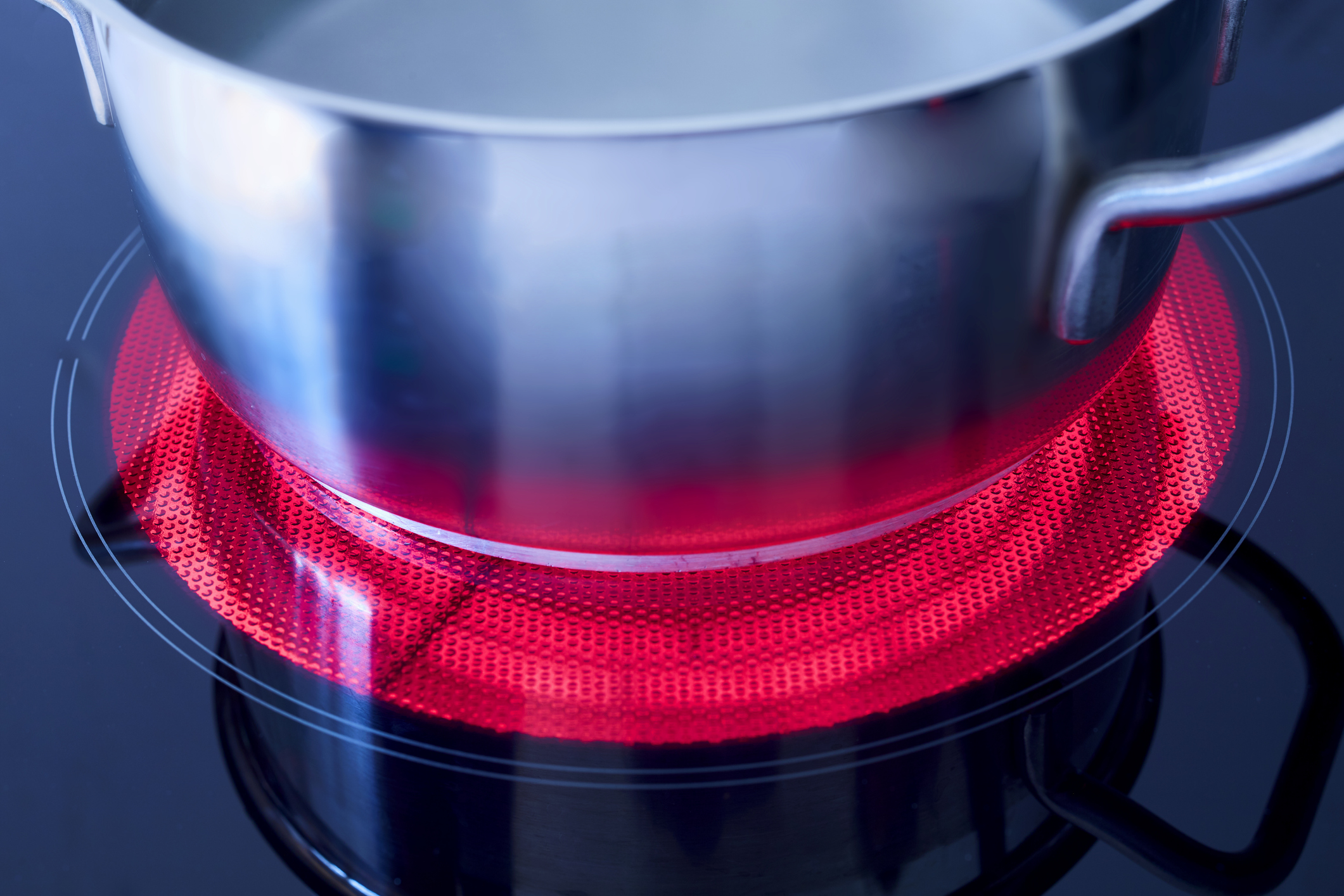 Ein Kochtopf auf einer angeschalteten, rot leuchtende Kochplatte