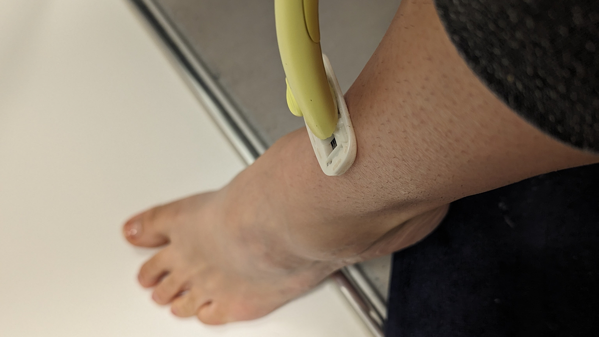 Ein Bein wird mit einem gelben Rasierer rasiert.