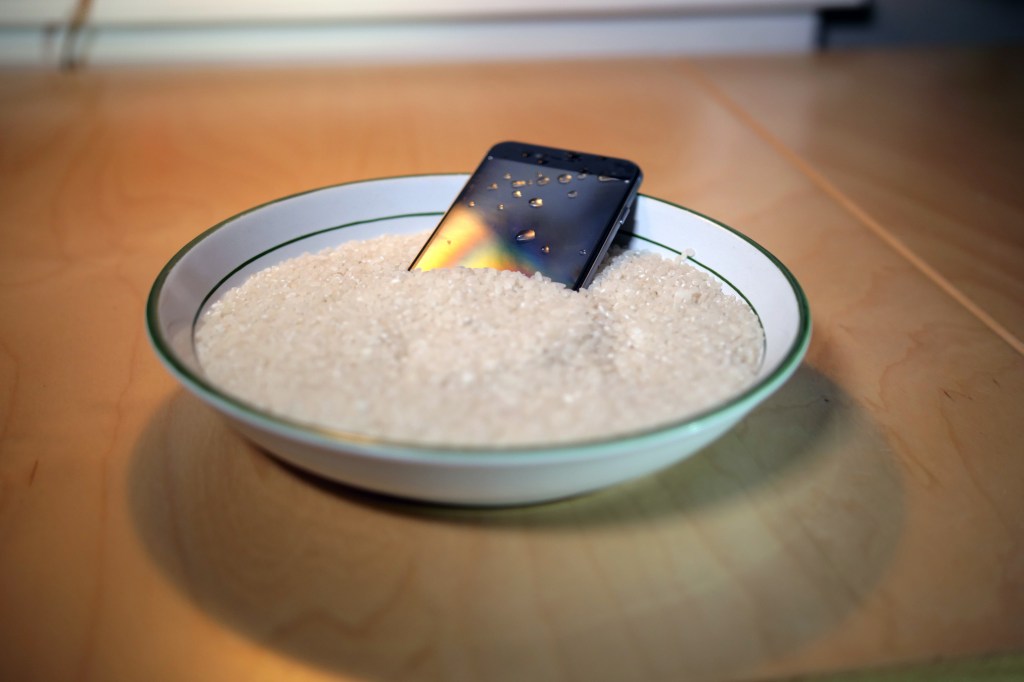 Ein Handy liegt auf einem Teller mit Reis.