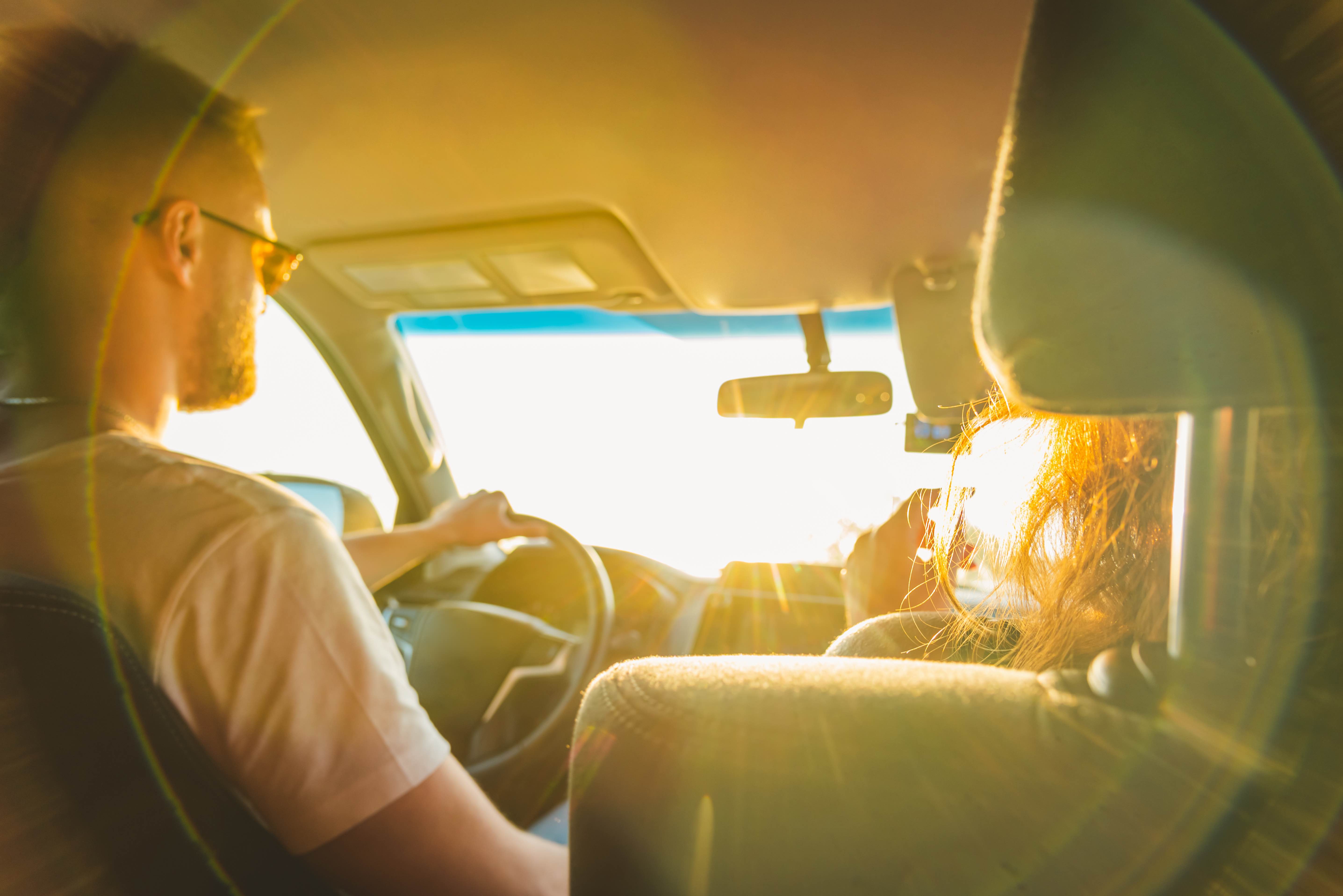 Ein Mann und eine Frau sitzen in einem Auto. Kann man durch die Autoscheibe einen Sonnenbrand bekommen?