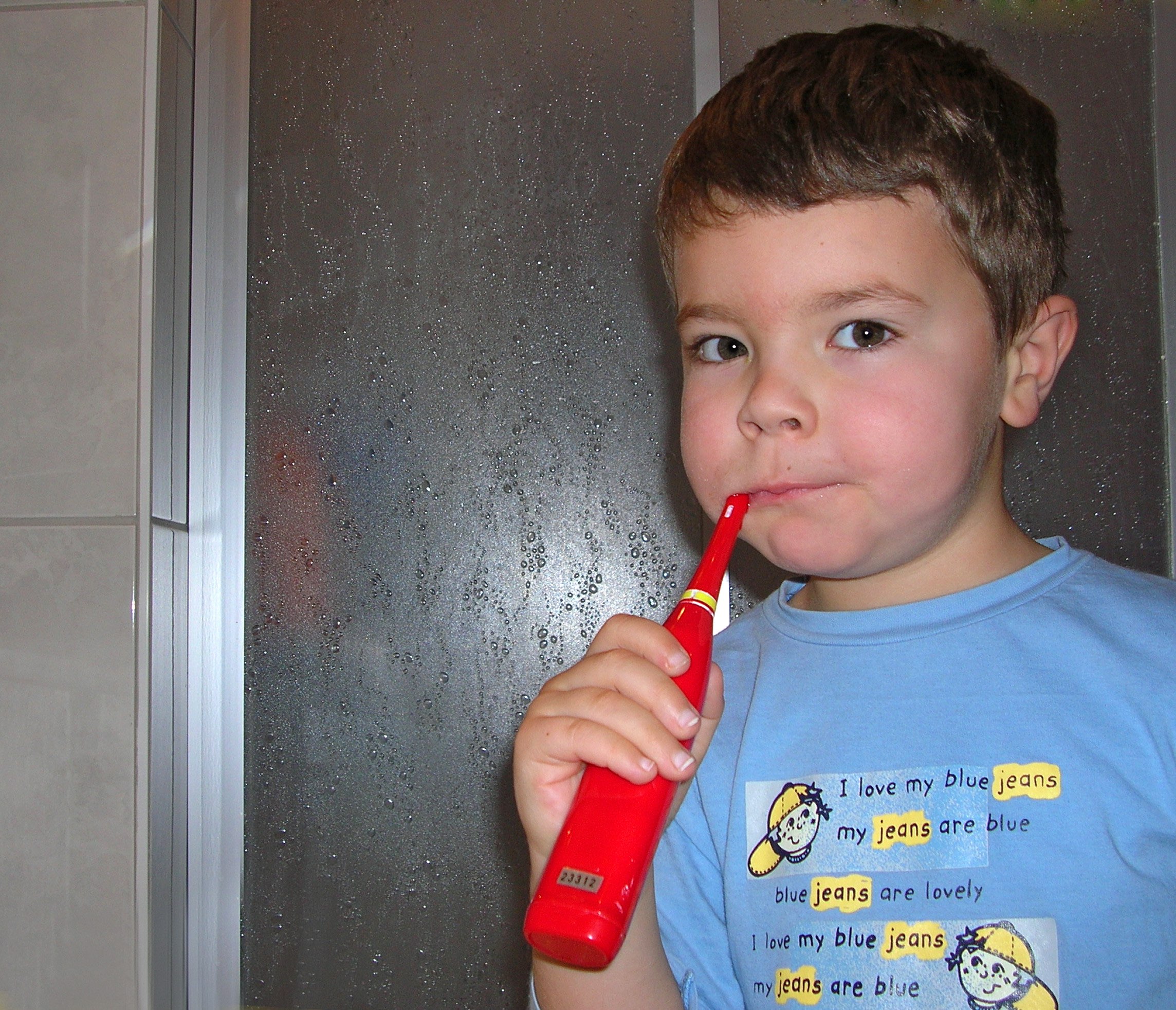 Ein kleiner Junge mit einer elektrischen ZahnbÃ¼rste. Sollte man die ZÃ¤hne besser vor oder nach dem FrÃ¼hstÃ¼ck putzen?