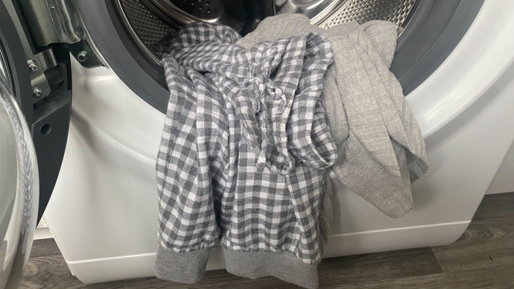 Ein grauer Schlafanzug liegt in der Waschmaschine.