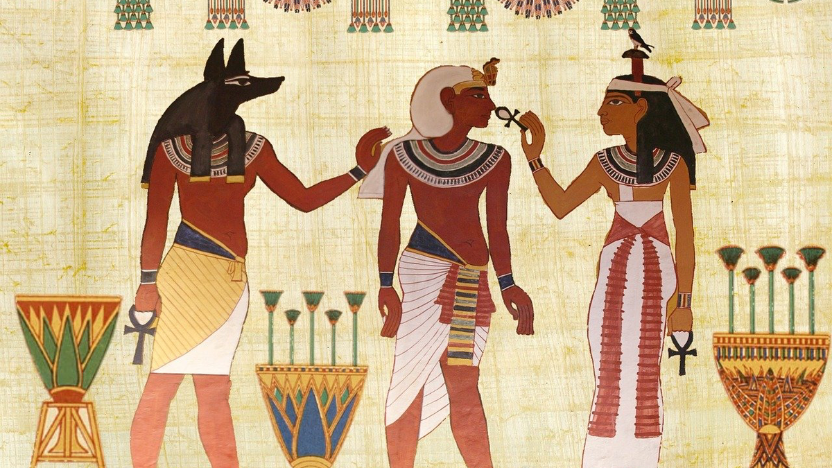 Das Bild eines ägyptischen Freskos mit drei Figuren darauf.