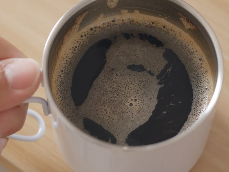 Jemand hält eine Tasse mit Kaffee in der Hand.
