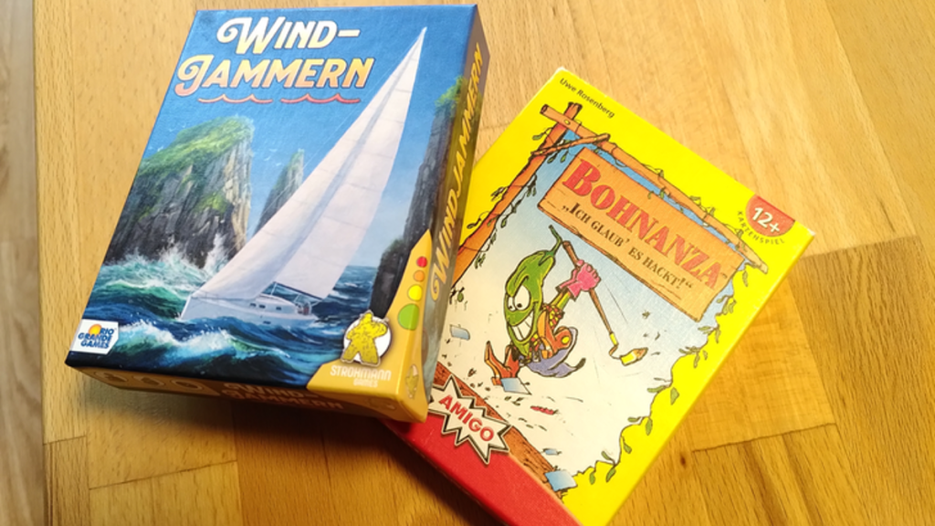 Die zwei Kartenspiele „Windjammern“ und „Bohnanza“ liegen auf einem hellen Holztisch.