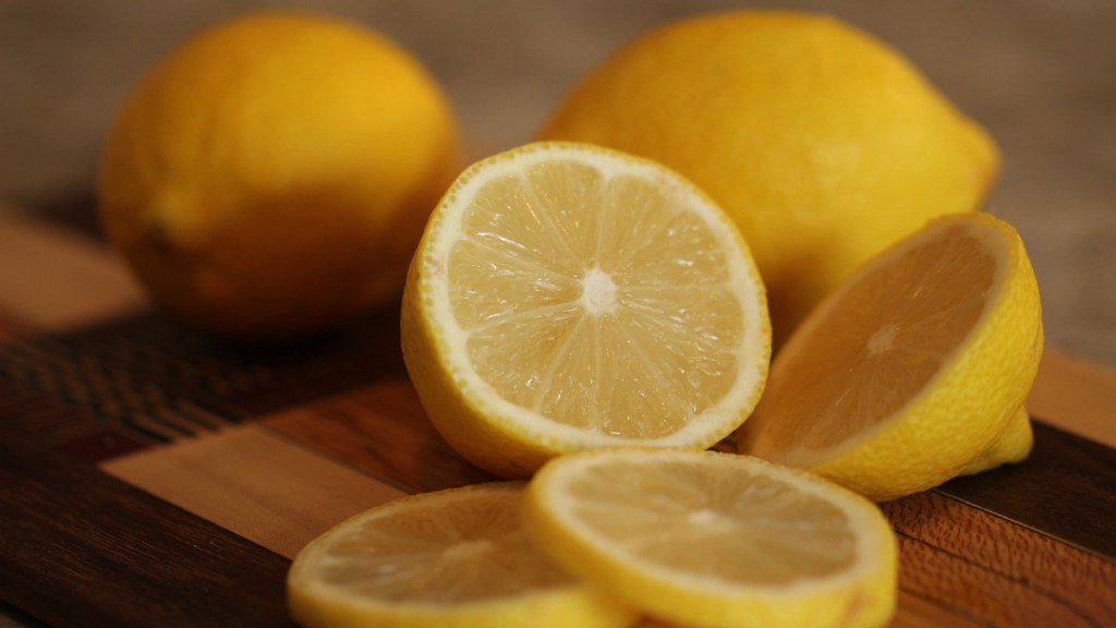 Eine aufgeschnittene Zitrone liegt auf einem Holzbrett.