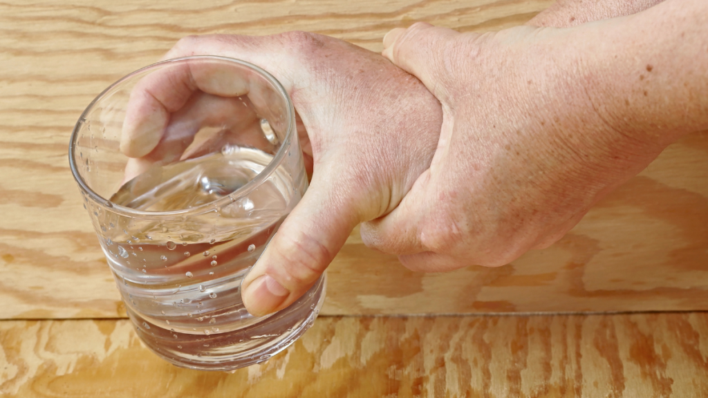 Jemand hält mit seinen Händen ein Wasserglas.