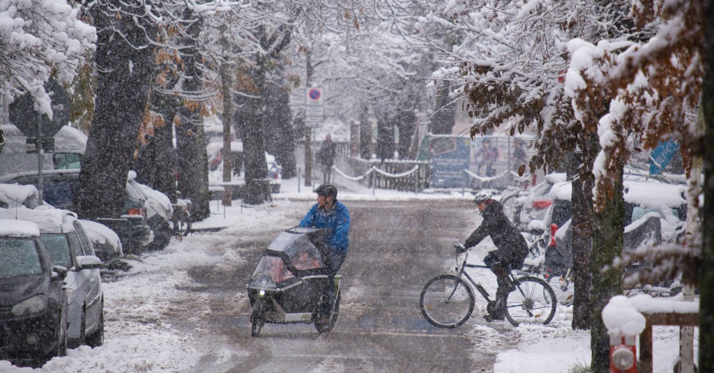 Zwei Fahrradfahrer im Schneegetümmel.