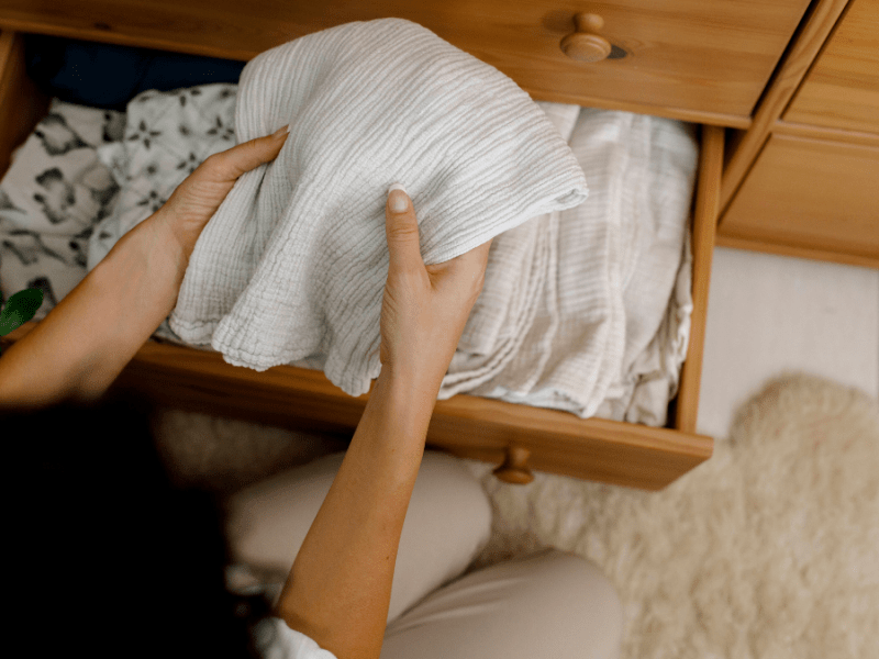 Frau räumt Bettlaken ein