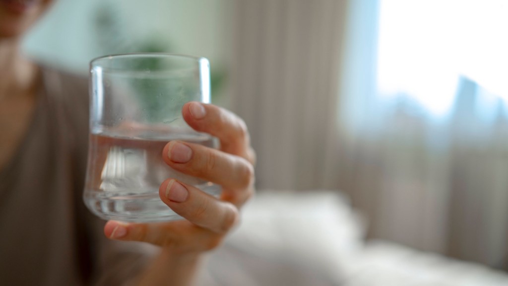 Flüssigkeitsmangel: Eine Frau hält ein Glas Wasser in der Hand.