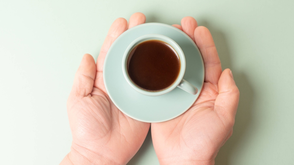 Kleine Tasse Kaffee in den Händen halten.