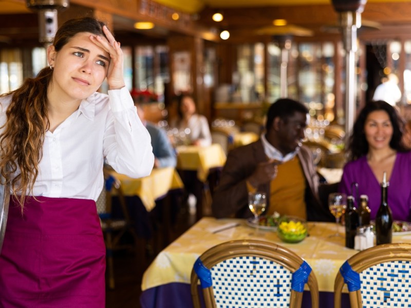 Ein Foto einer müden, genervten Kellnerin in einem Restaurant.