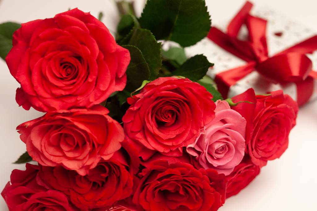 Ein Strauß roter Rosen  liegt auf einem Tisch.