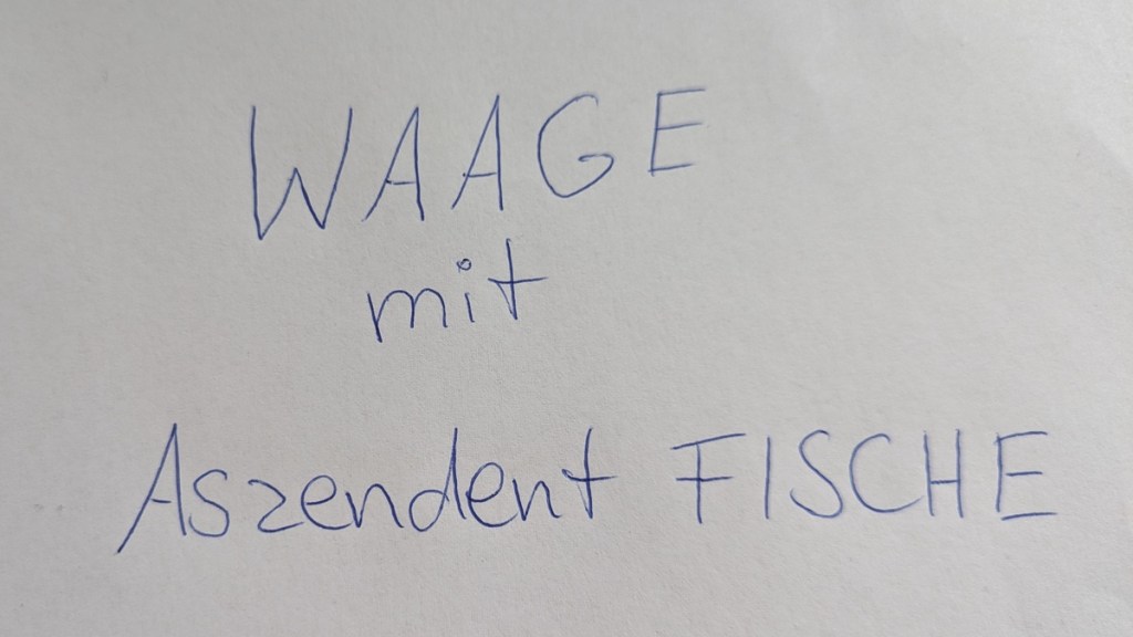 Auf einem Blatt Papier steht „Waage mit Aszendent Fische“.