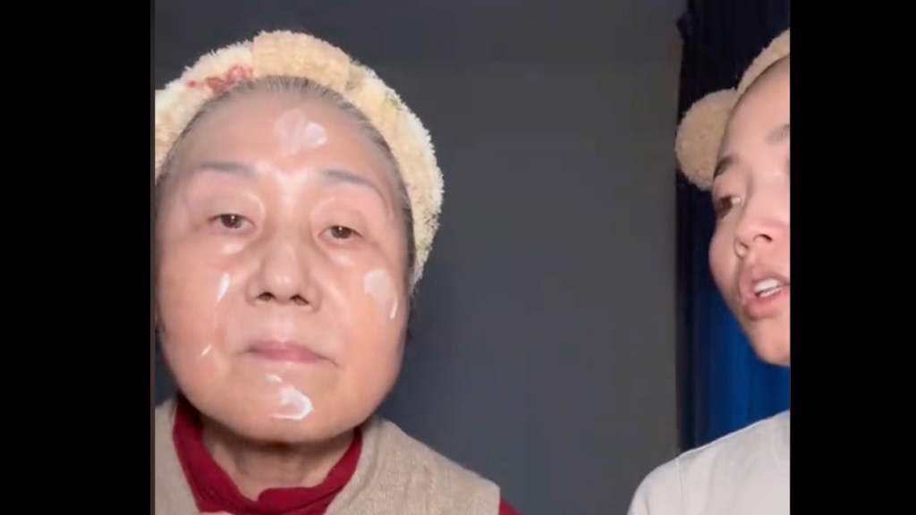 Eine ältere und junge Frau filmen sich bei ihrer Gesichtspflegeroutine.