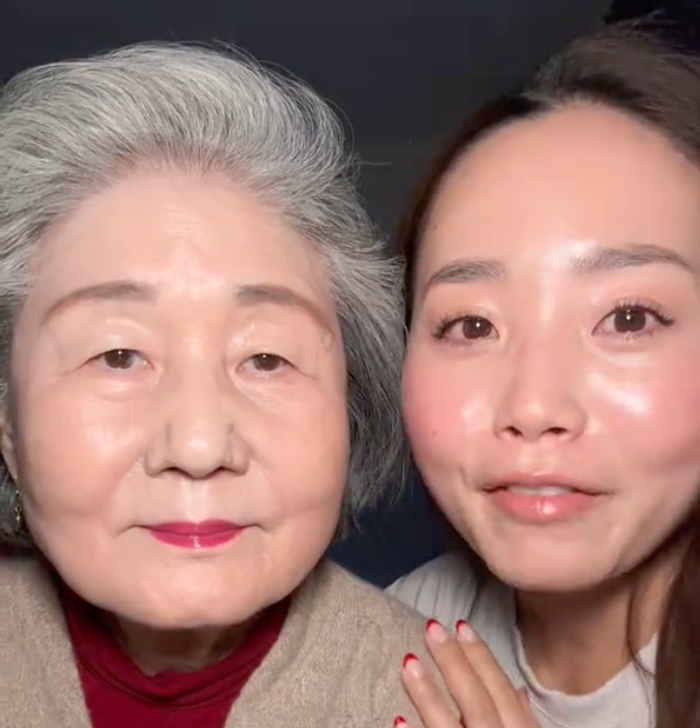 Eine alte Frau und eine junge Frau lächeln in die Kamera.