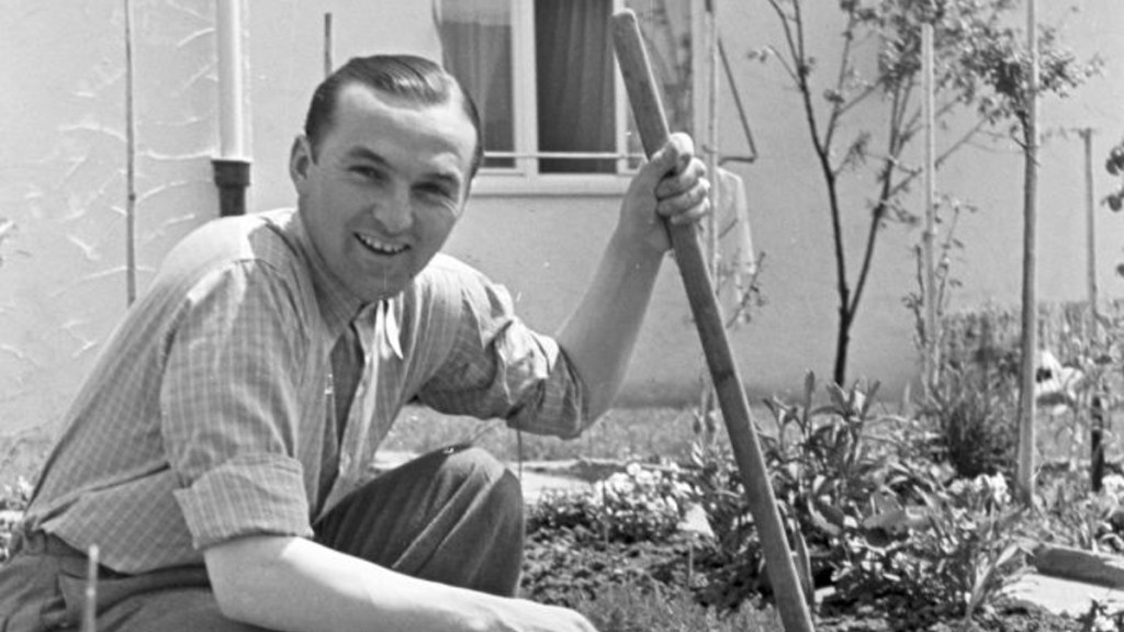 Ein Schwarz-weiß-Bild des Rennfahrers Hermann Lang bei der Gartenarbeit.