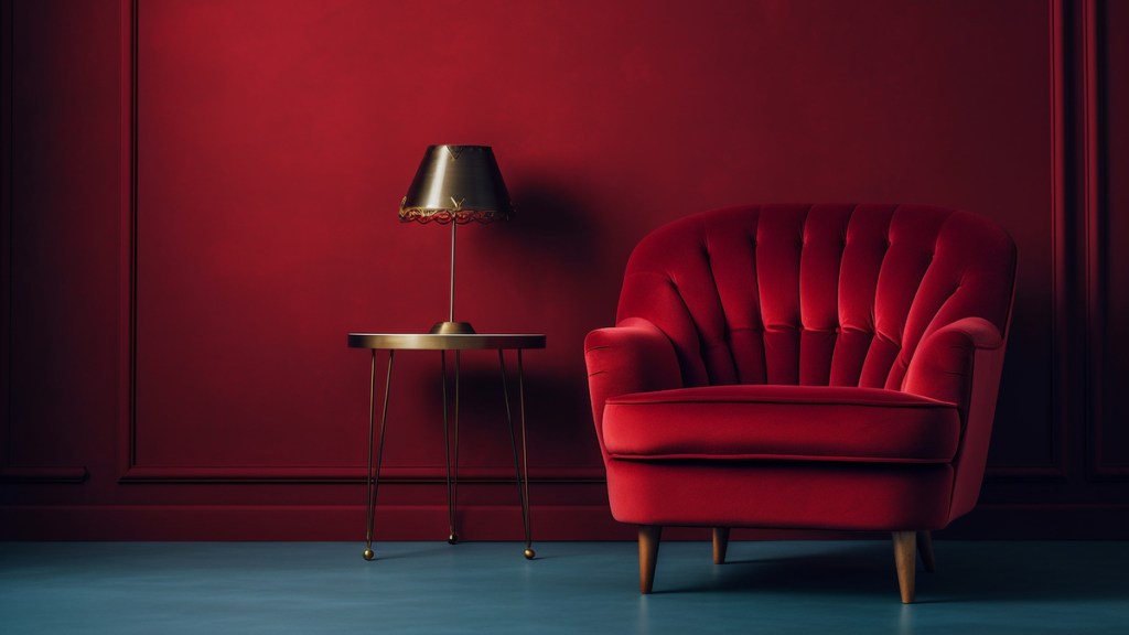 Eine rote Wand mit einem roten Sessel, einem goldenen Beistelltisch und einer Lampe darauf.
