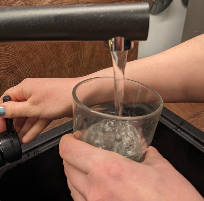 Ein Wasserglas wird mit Leitungswasser befüllt.
