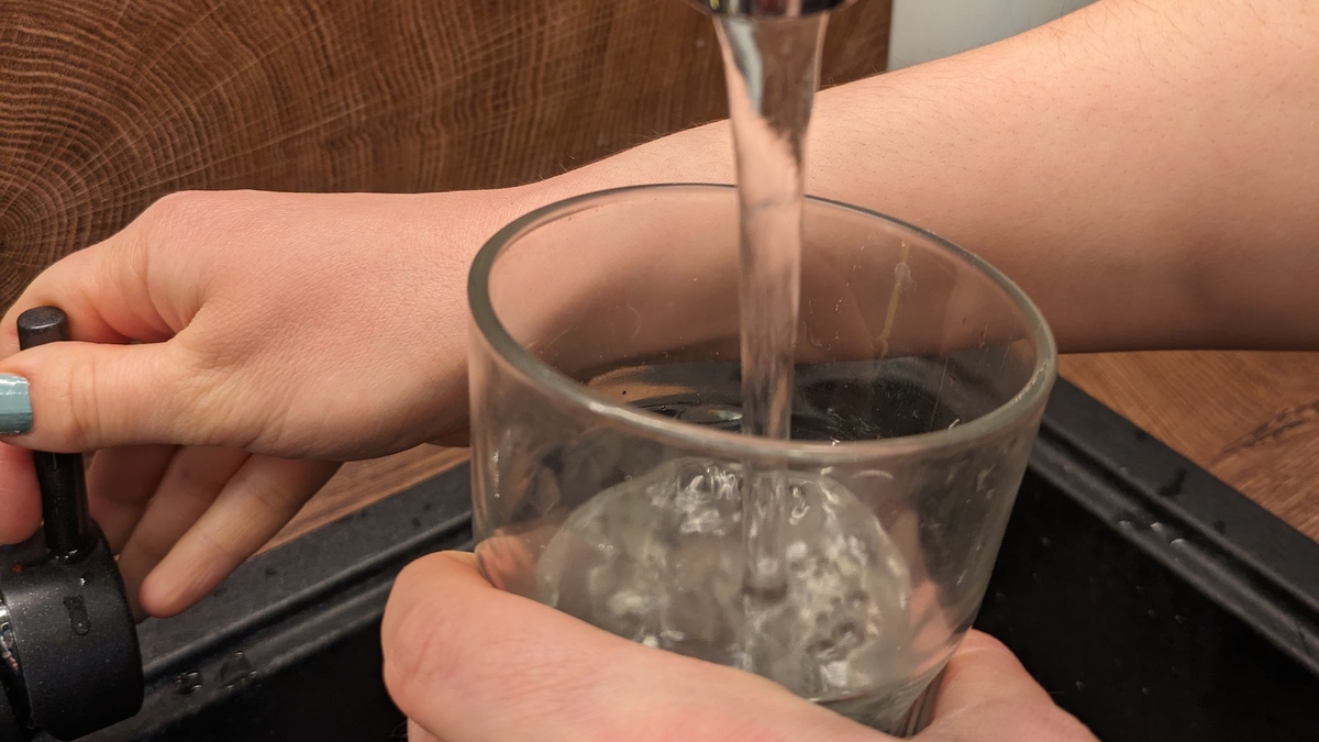 Ein Wasserglas wird mit Leitungswasser befüllt.