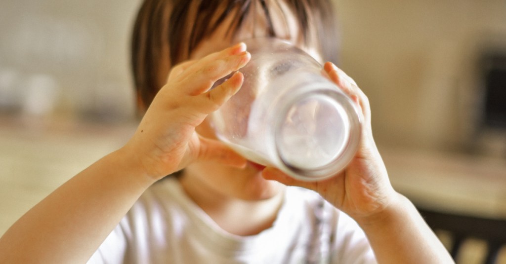 Ein Junge trinkt ein Glas Milch.