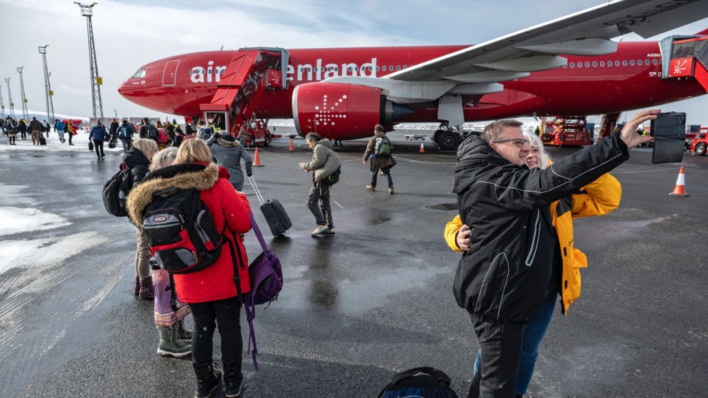 Zwei Menschen machen vor einem Flugzeug ein Selfie.