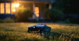 Mähroboter mäht einen Rasen in der Dunkelheit