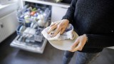 ein Teller wird mit einem Geschirrhandtuch abgetrocknet