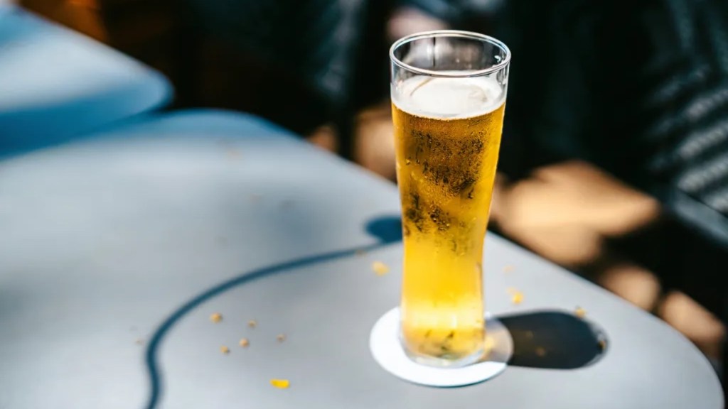 Ein Glas Bier auf einem Tisch.