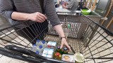 Einkauf am Kassenband im Supermarkt einpacken.