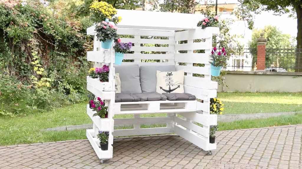 Ein selbstgebauter Strandkorb steht in einem Garten.