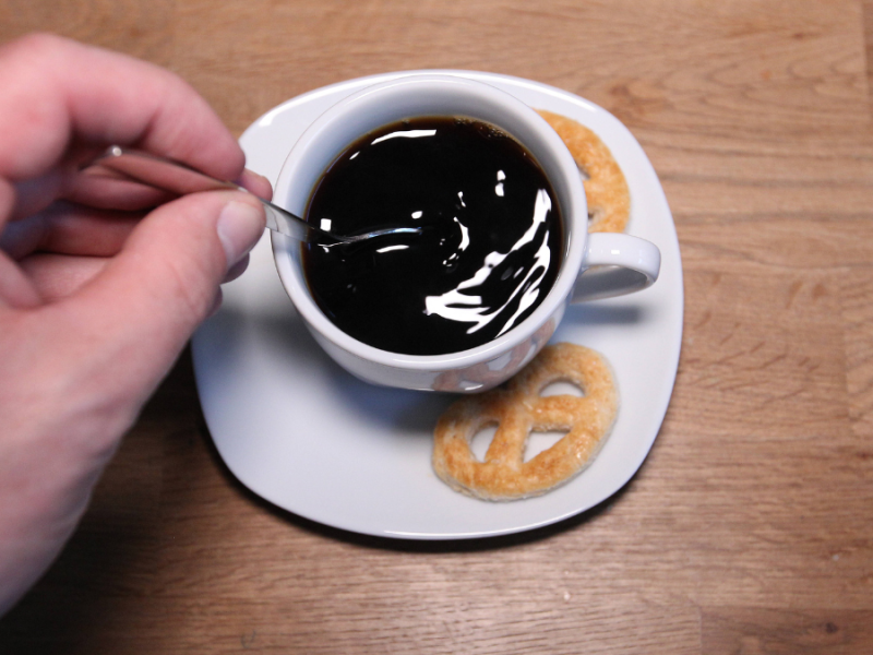 Kaffee in einer Kaffeetasse, Hand rü