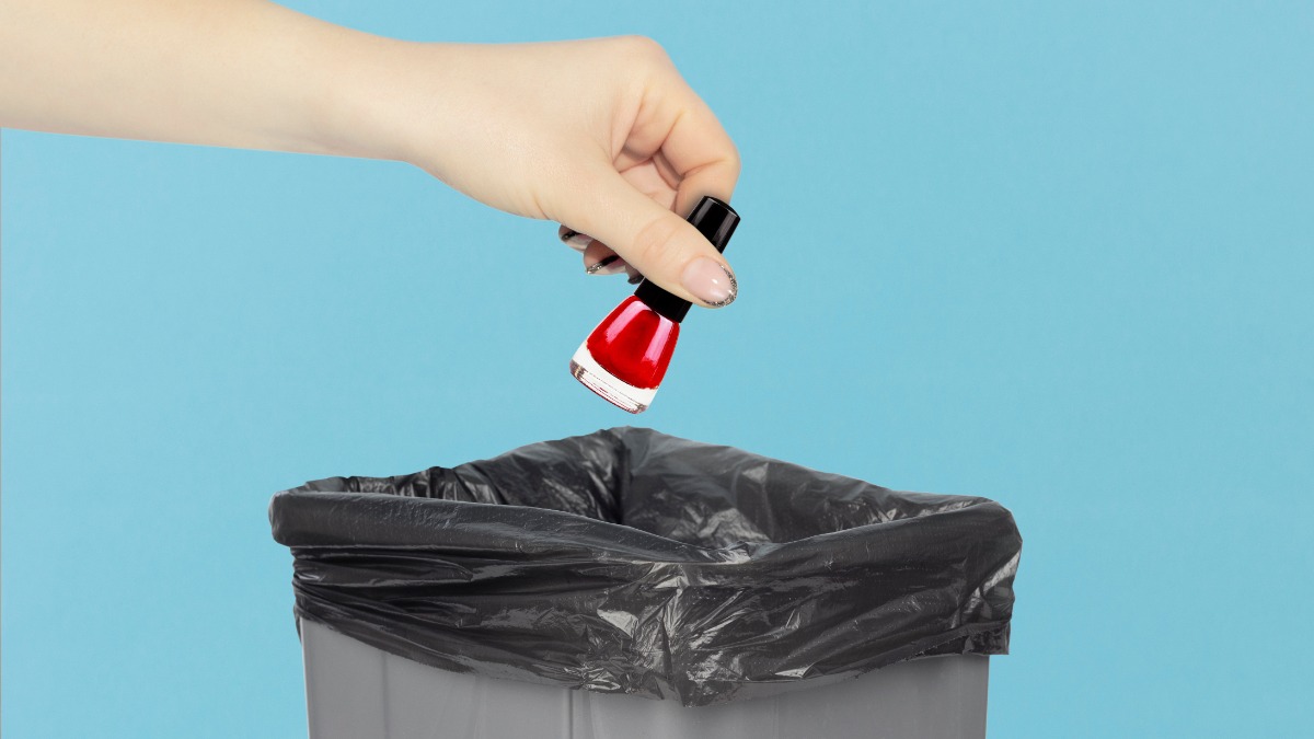 Eine Person wirft ein Nagellackfläschchen in den Mülleimer.