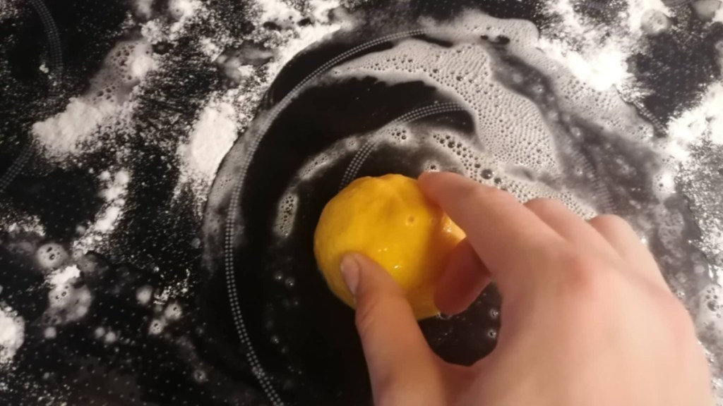 ein Ceranfeld wird mit einer Zitrone gereinigt