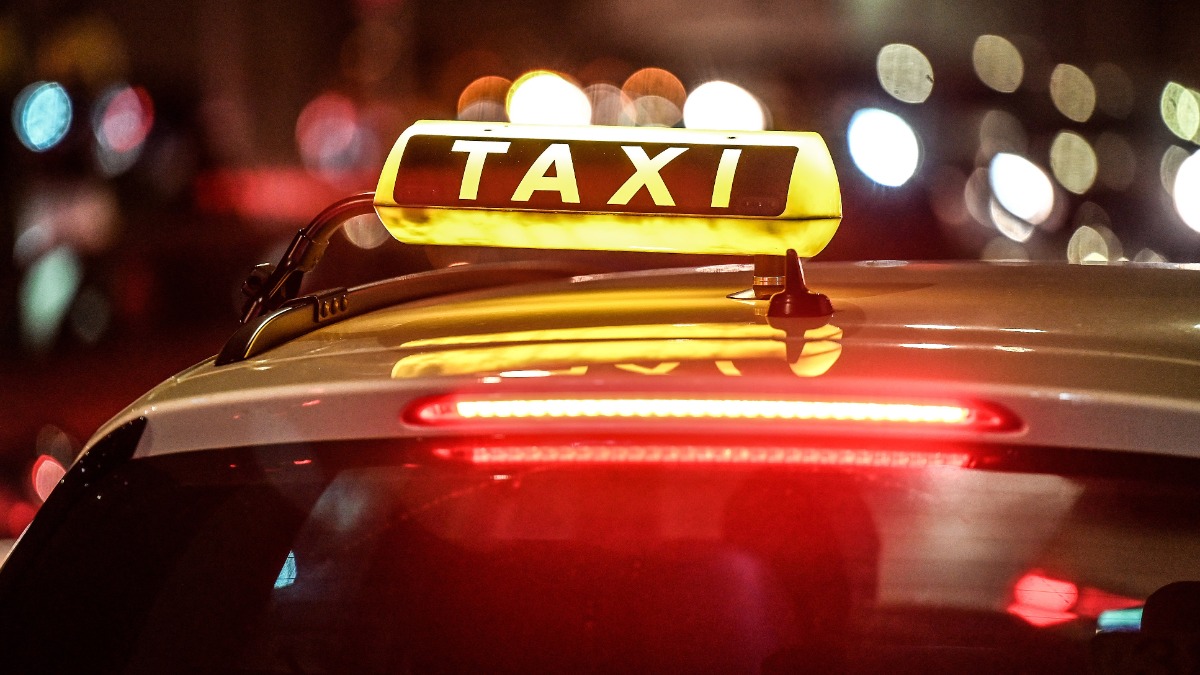 Taxifahrer: ein Taxi steht nachts an einer Straße