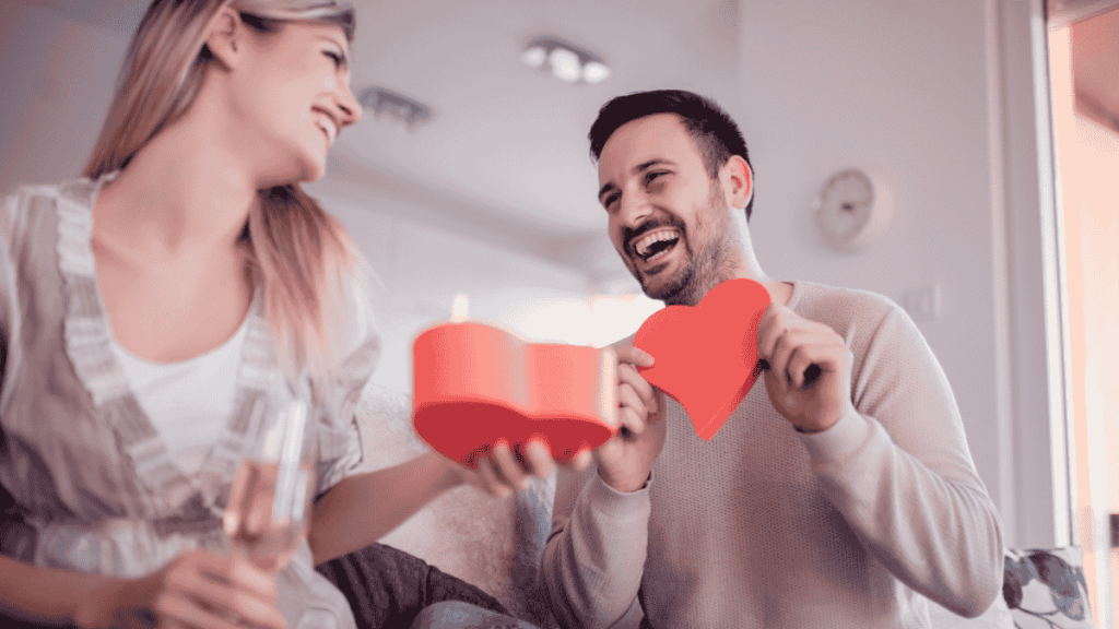 Valentinstags-Date-Box-Ideen, Paar packt Geschenk in Herzform aus.