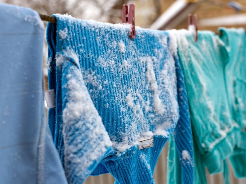 Wäsche im Winter draußen trocknen: Wäsche hängt auf einer Leine und ist mit Schnee bedeckt
